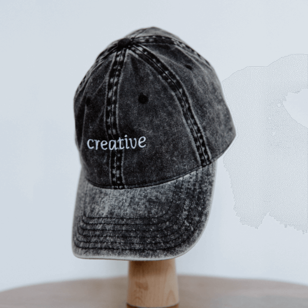 Grey embroidered hat with the word "Creative"